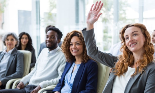 female executive raising hand meeting