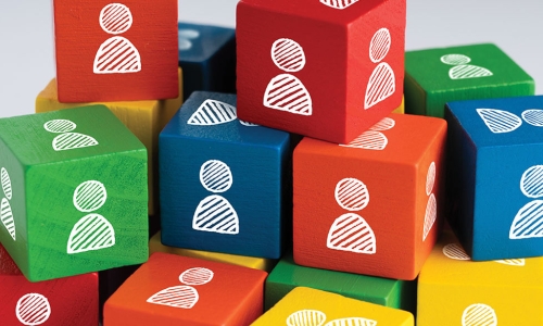 stack of colorful blocks with people drawings on them with camera focused on middle of stack