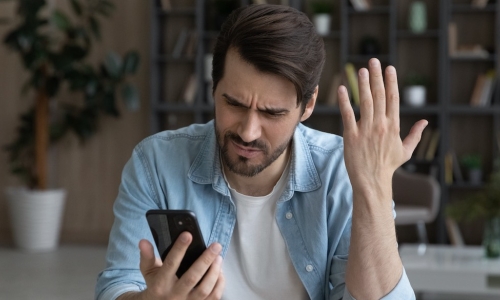 upset young man looking at phone