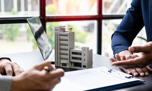 document on desktop while individuals talk over it