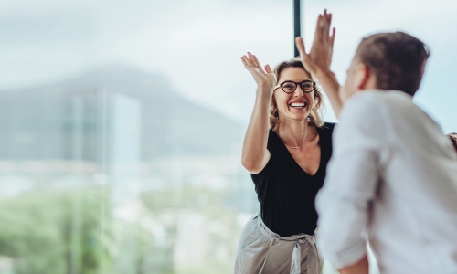 woman and man high-fiving over a table