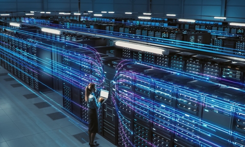 Woman standing in front of wall of computer servers