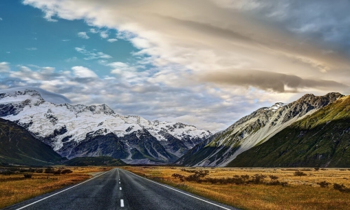 road leading up to whitecapped mountains