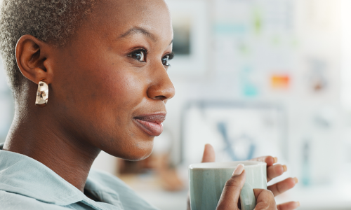 woman looking reflective holding a cup of coffee