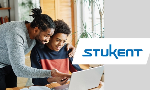 man looking over boys shoulder at computer screen