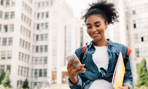 Gen Z lady walking down street looking at cell phone