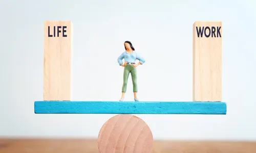 woman balancing work and life blocks on a seesaw
